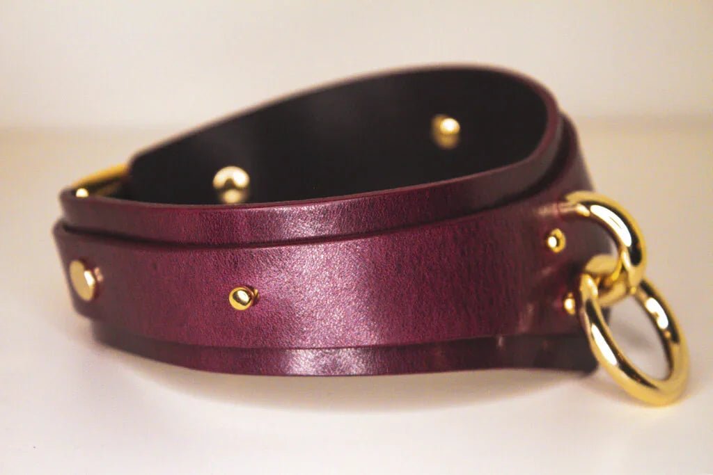 Side view of a submissive Bordeaux Italian leather BDSM collar with a gold-tone buckle and loop.