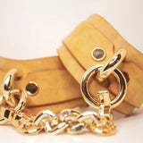 Stacked Golden Hour leather BDSM cuffs with gold-tone details on a neutral background.