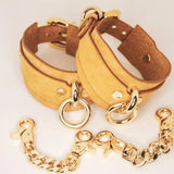 Golden Hour handmade BDSM cuffs with gold-tone buckle and rivets.