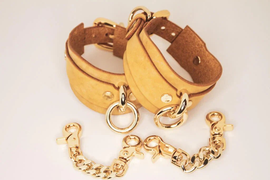 Golden Hour handmade BDSM cuffs with gold-tone buckle and rivets.