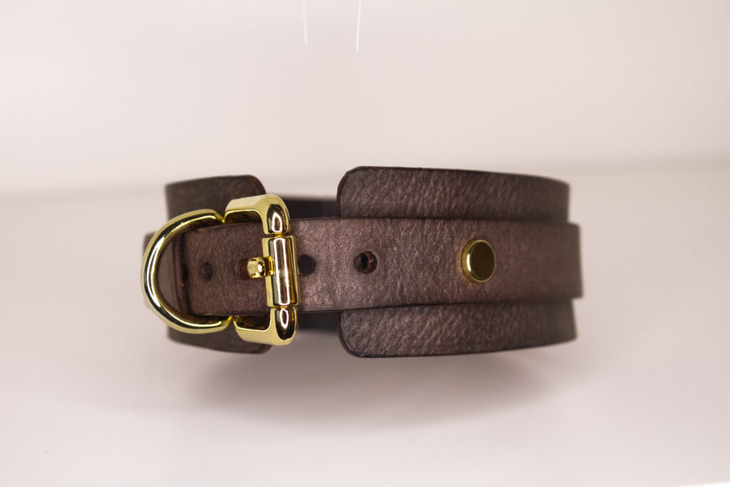 Detailed view of the buckle fastening of the 'Mesa' brown leather BDSM collar, highlighting the precision stitching and gold-tone hardware.