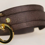 Angled perspective of the 'Mesa' brown leather BDSM collar showing off the wraparound leather strap and elegant gold-tone O-ring centerpiece.