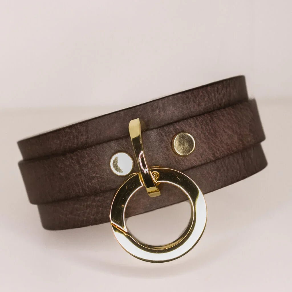 Luxurious 'Mesa' brown leather BDSM collar featuring a polished gold-tone O-ring and button studs against a white backdrop for a high-contrast presentation.