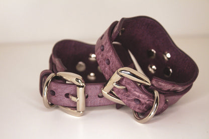 Rear view of Haze purple leather BDSM cuffs with silver-tone O-rings and buckles.