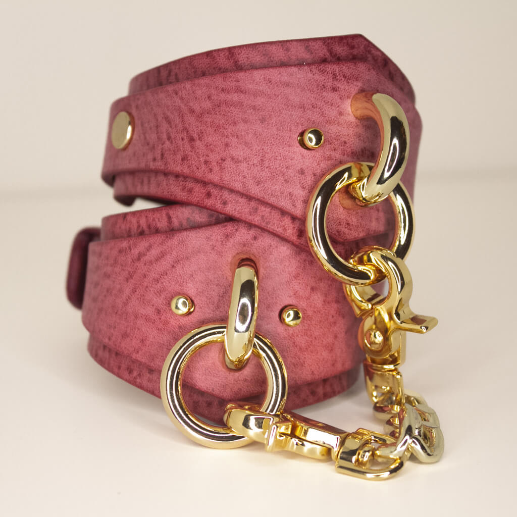 Luxurious handmade Desert Rose Italian leather cuffs with golden O-rings and chunky chain.