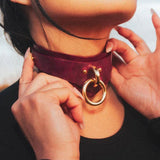 Person clasping a Bordeaux Italian leather BDSM collar, displaying its handmade elegance.