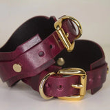 Back detail of Bordeaux leather BDSM cuffs with gold-tone buckle and loop.