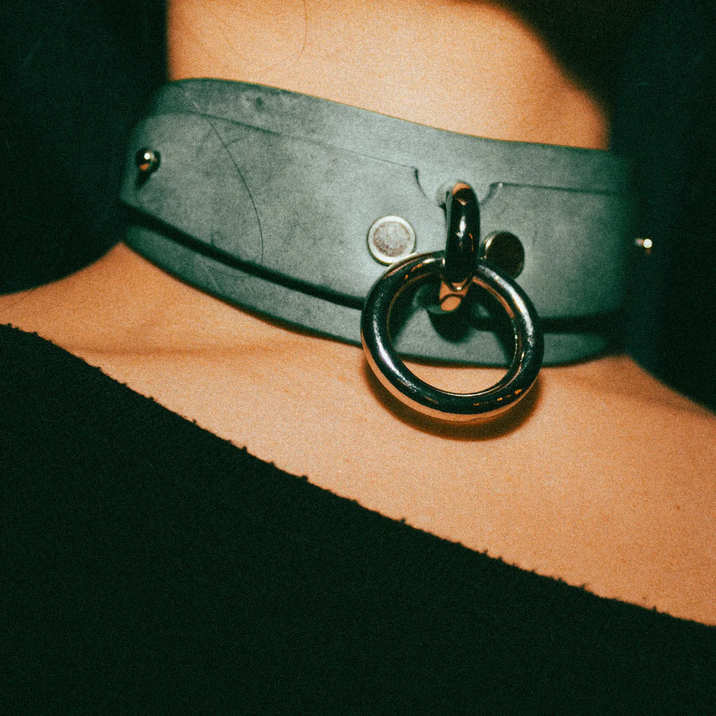 Gray leather day collar with metal ring detail worn on neck, showcasing custom leather collars