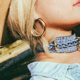 side view woman outside wearing cowboy core blue leather bdsm collar and hat