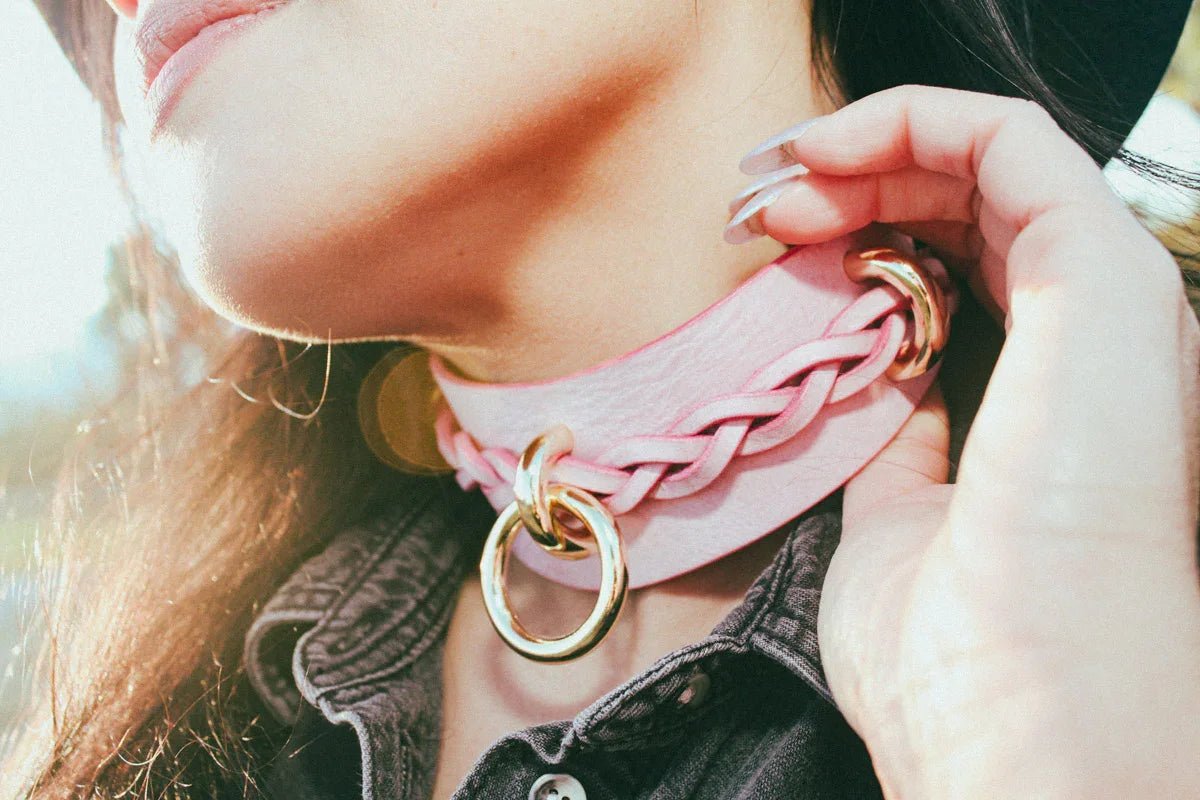 woman grabbing pink luxury bdsm collar in cowboy core style