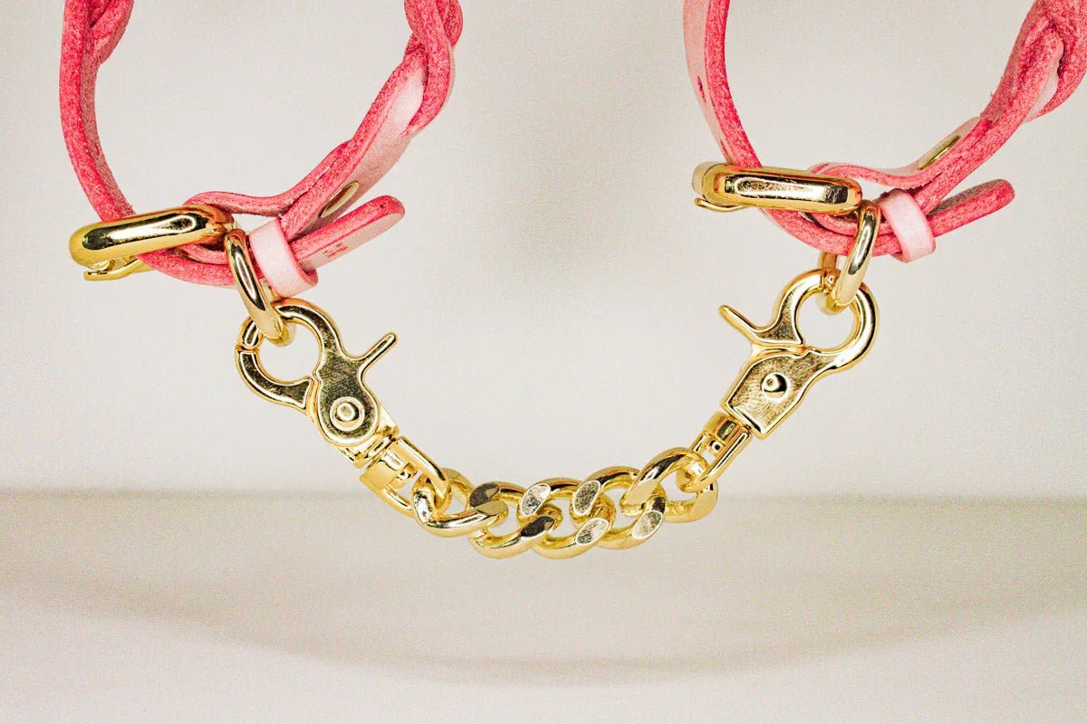 Pink leather day collar with gold chain and clasps, showcasing leather collars and leather wrist cuffs