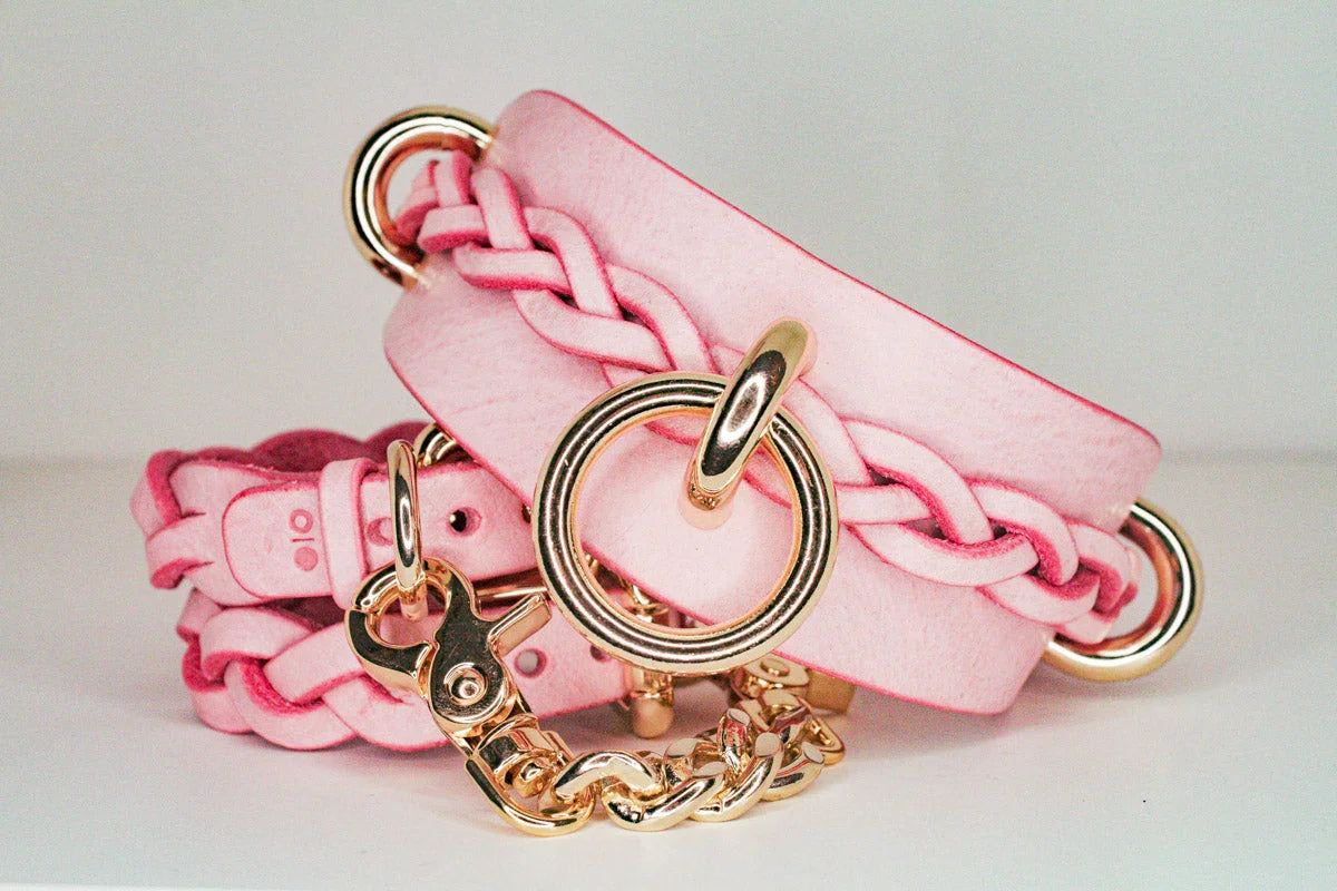 Pink leather day collar and leather wrist cuffs with gold hardware and braided details