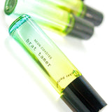 Neon Coyotes brat tamer pocket perfume vial with black cap, part of collection including three yellow-green glass bottles
