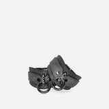 Pair of dark leather wrist cuffs with metal rings, black hardware on plain background