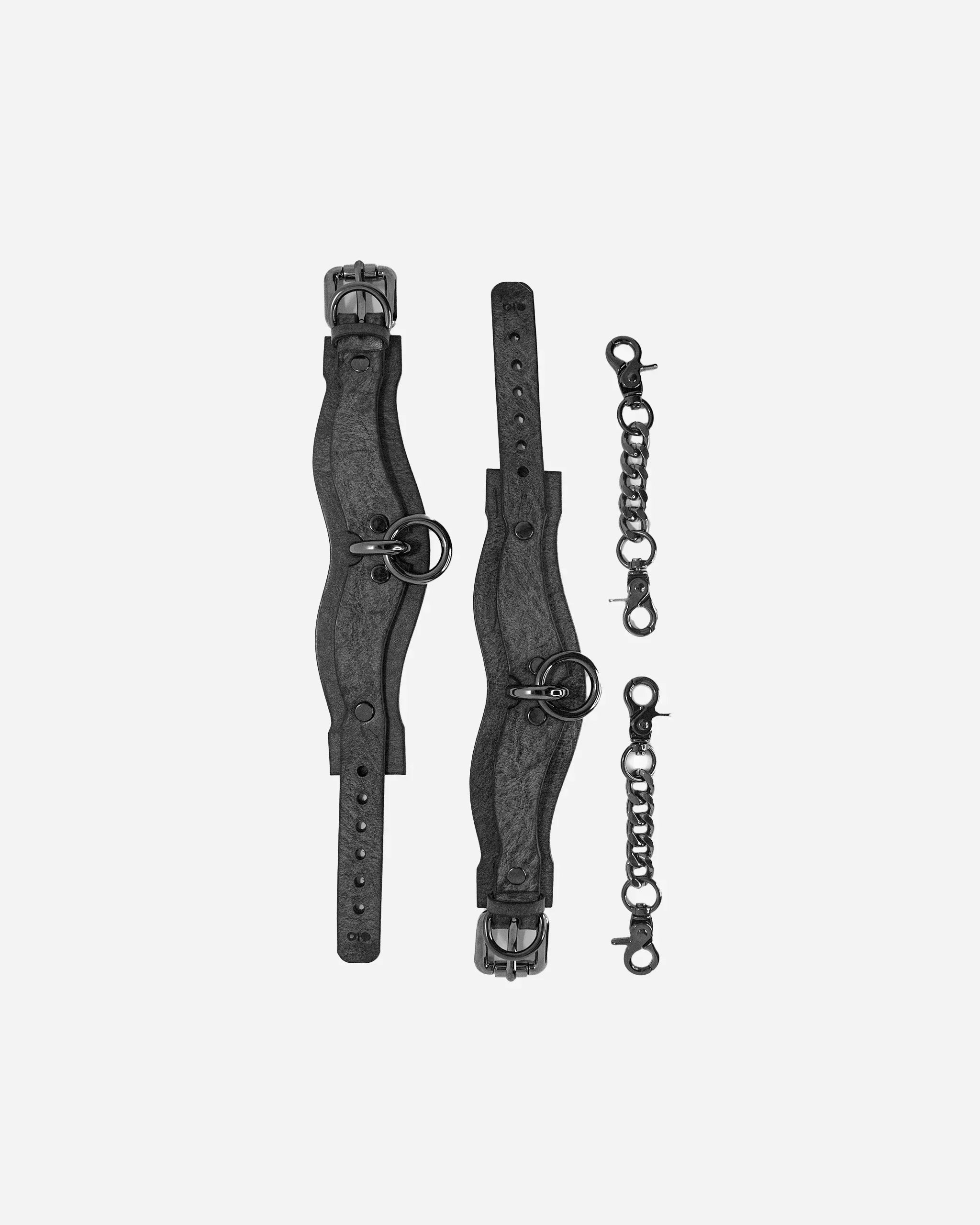 Black leather cuffs with curved design and metal rings, paired with two black metal chain connectors