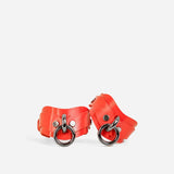 Pair of custom red handcuffs on a white background