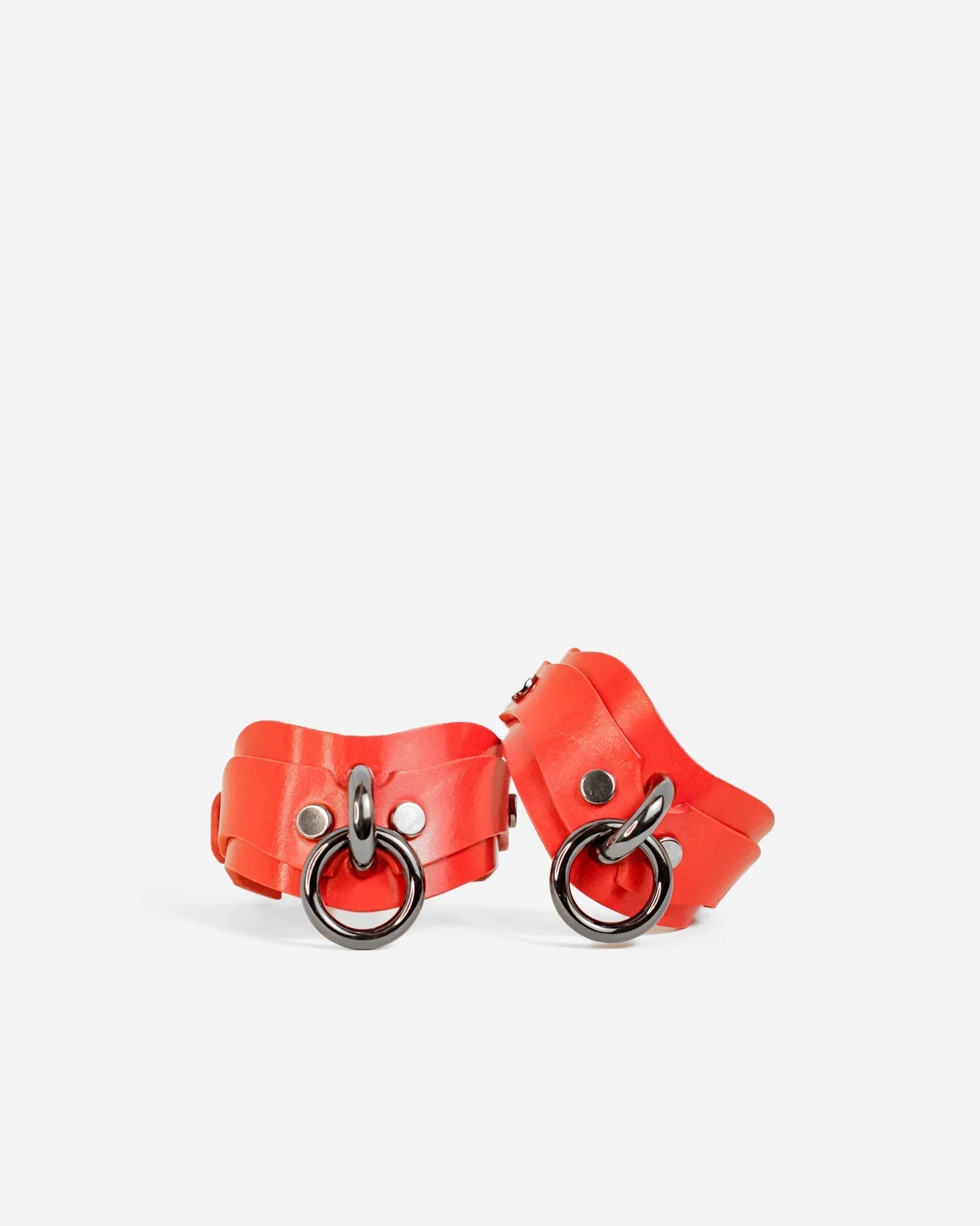 Pair of custom red handcuffs on a white background