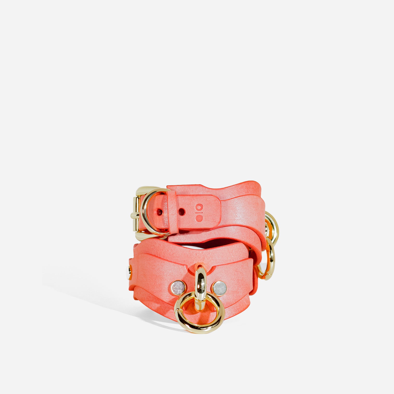 light orange handcuffs with gold hardware on a white background