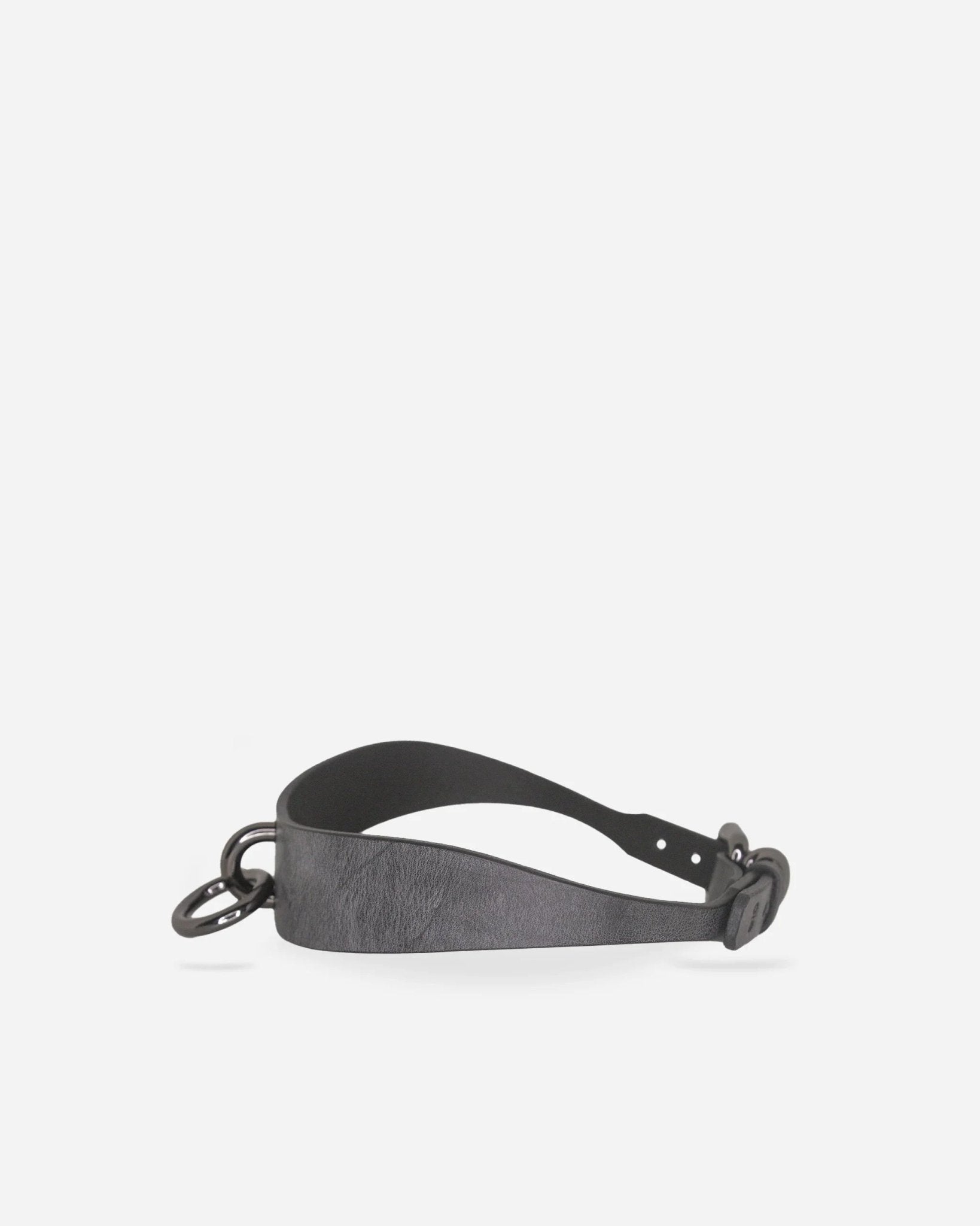 Black leather day collar with metal O-ring and buckle, minimalist design on white background