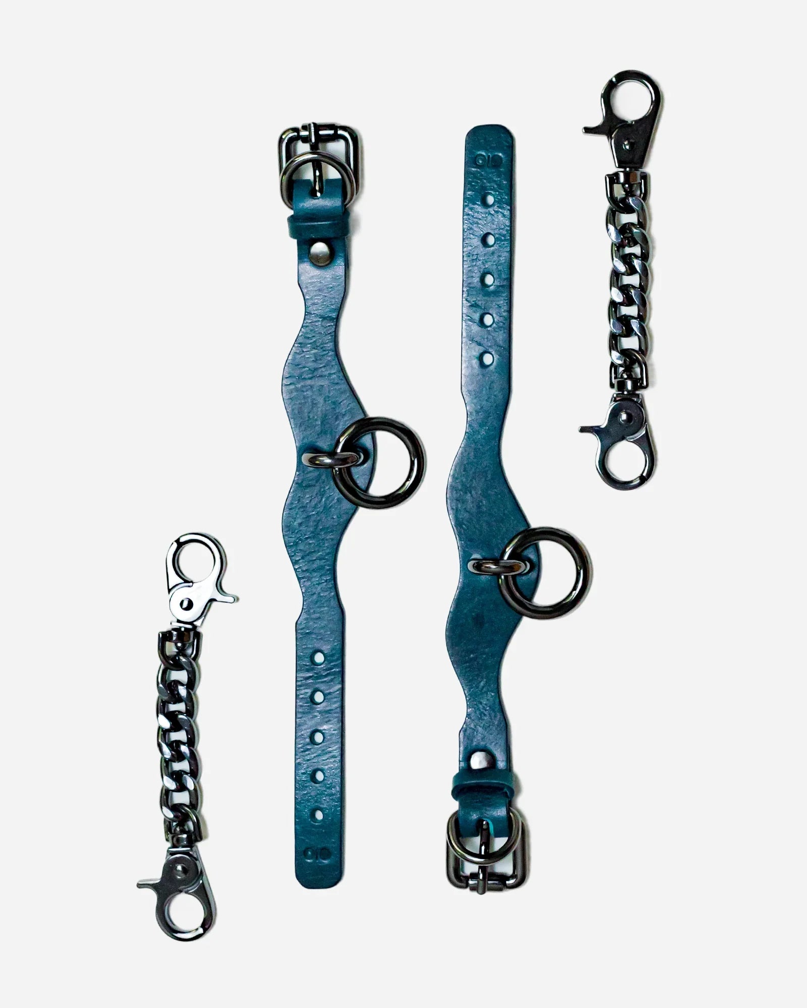 Blue Italian leather wrist cuffs with metal rings and chain connectors on white background