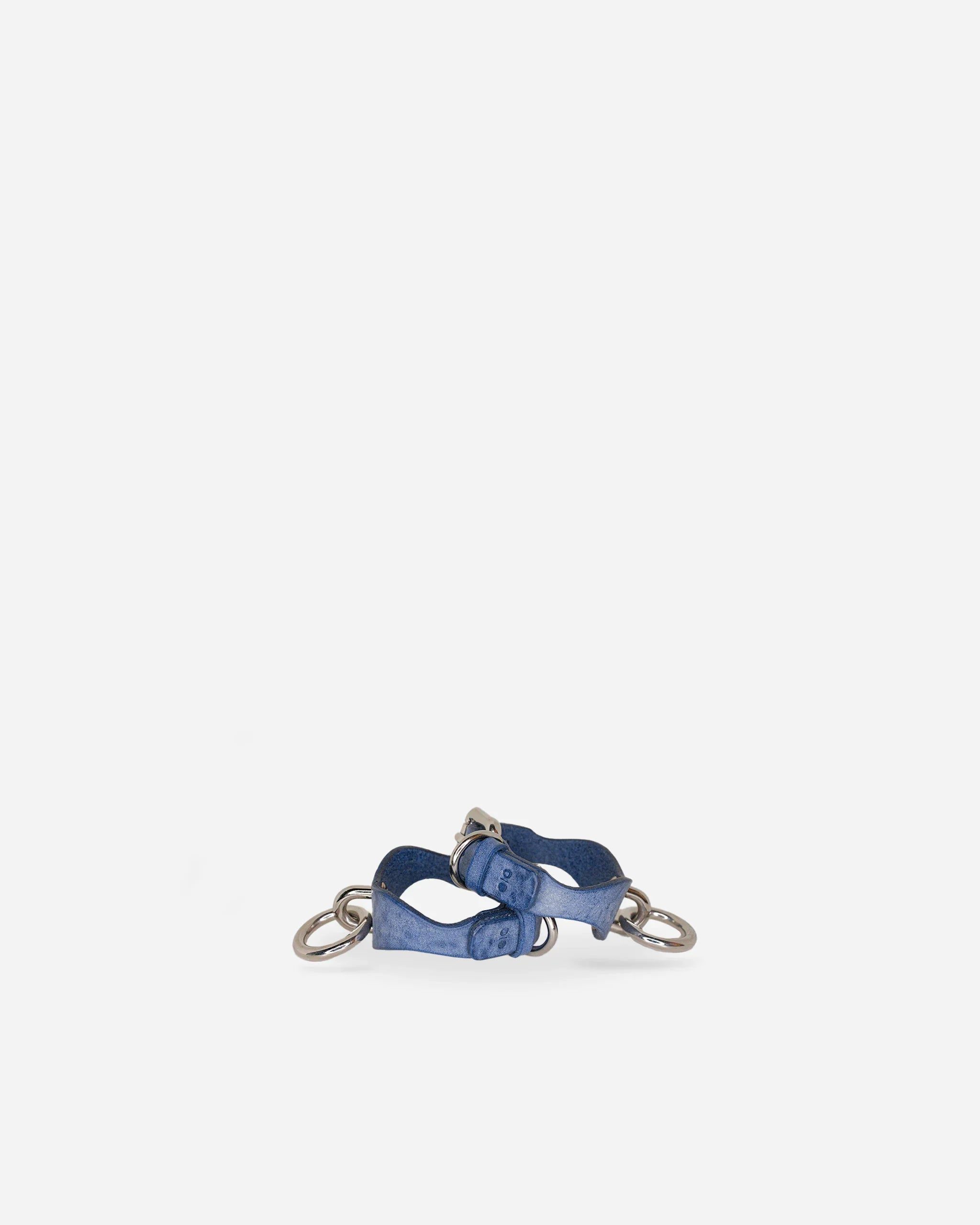Pair of blue leather wrist cuffs with metal rings and buckles on white background