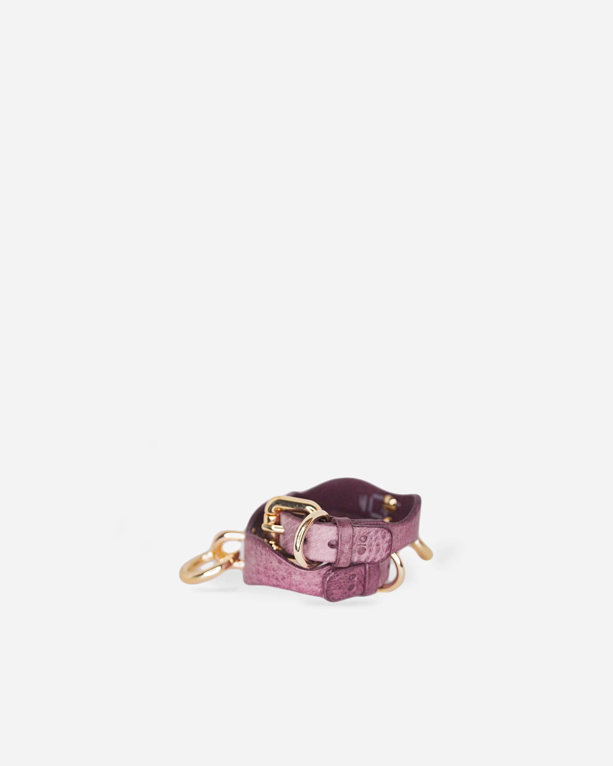 Purple full-grain Italian leather wrist cuffs with gold hardware on white background, leather cuffs