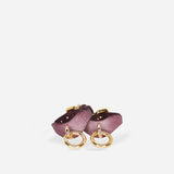 Pair of purple leather wrist cuffs with gold rings and buckles on a white background