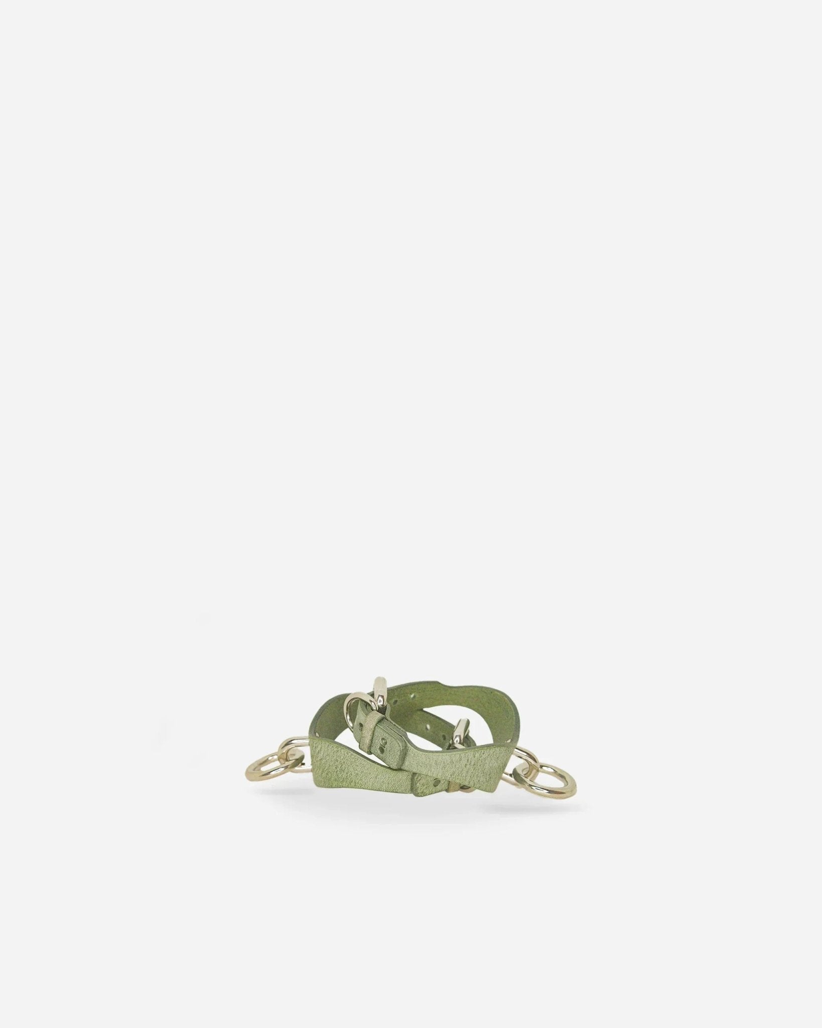 Green Italian leather cuffs with silver metal rings and buckle on white background, leather wrist cuffs