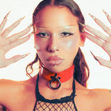 Person wearing a black fishnet top with a red leather bdsm collar against a white background